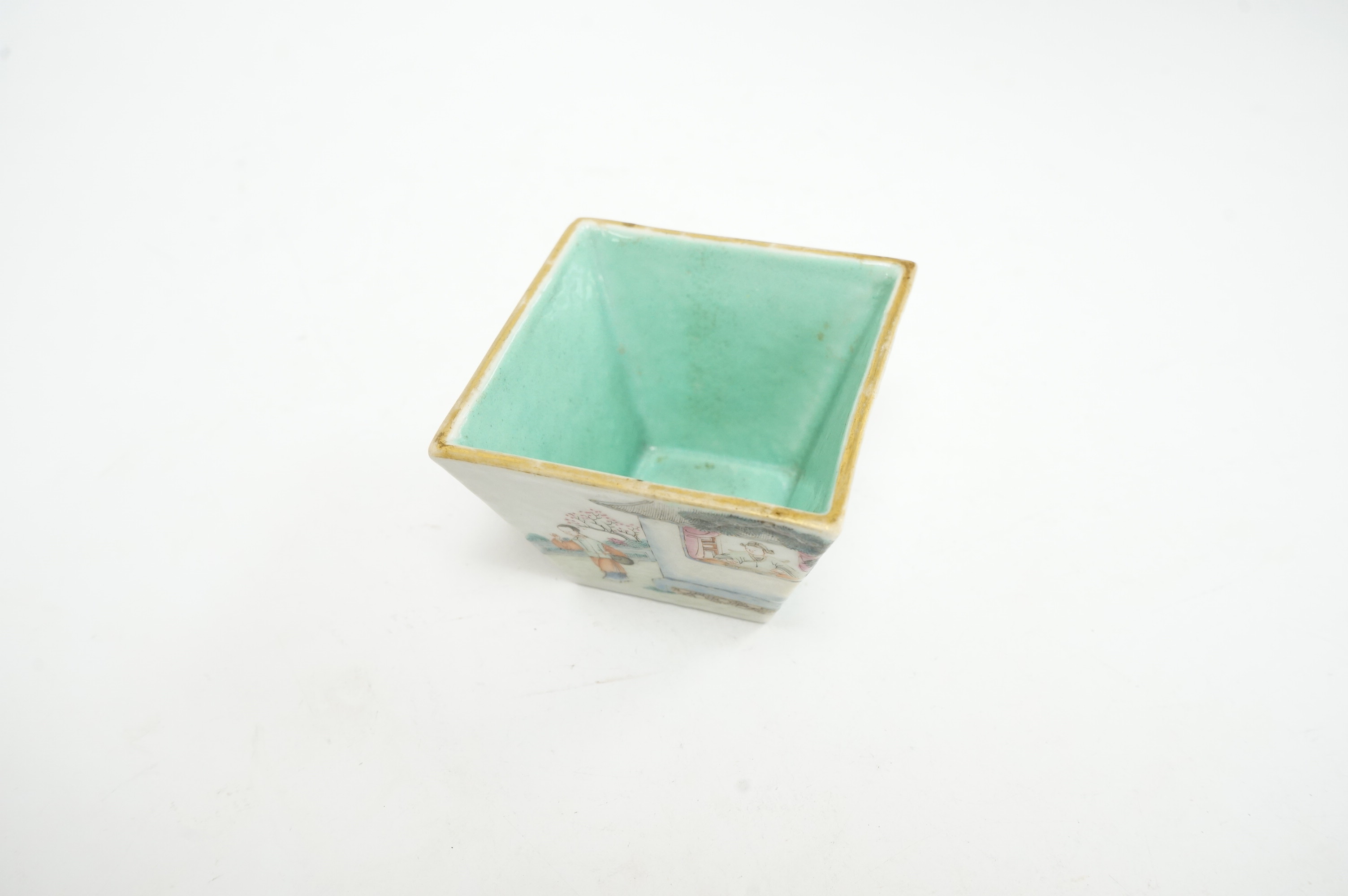 A Chinese famille rose small square bowl, Qianlong seal mark but Daoguang period (1821-50), finely painted with figures in a garden, the interior with turquoise glaze, iron red six character mark to base, 7.5cm wide. Con